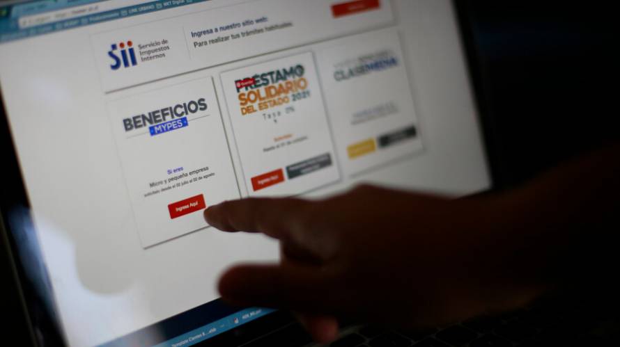 Mano apuntando a pantalla de laptop que muestra sitio web del Servicio de Impuestos Internos.